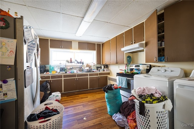 kitchen featuring washing machine and dryer, appliances with stainless steel finishes, a paneled ceiling, and light hardwood / wood-style flooring