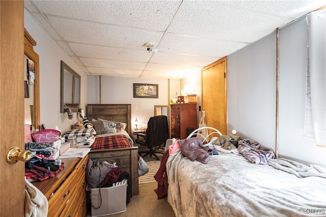 bedroom featuring a drop ceiling and carpet flooring