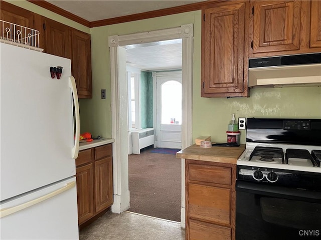 kitchen with gas range oven, white refrigerator, light carpet, radiator, and ornamental molding