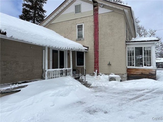 view of snow covered back of property