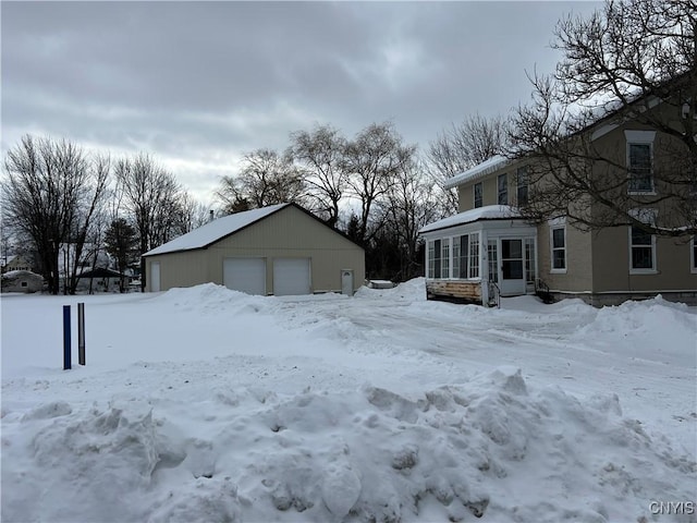 yard covered in snow with an outbuilding and a garage