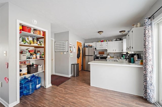 kitchen featuring sink, stainless steel appliances, dark hardwood / wood-style flooring, kitchen peninsula, and white cabinets