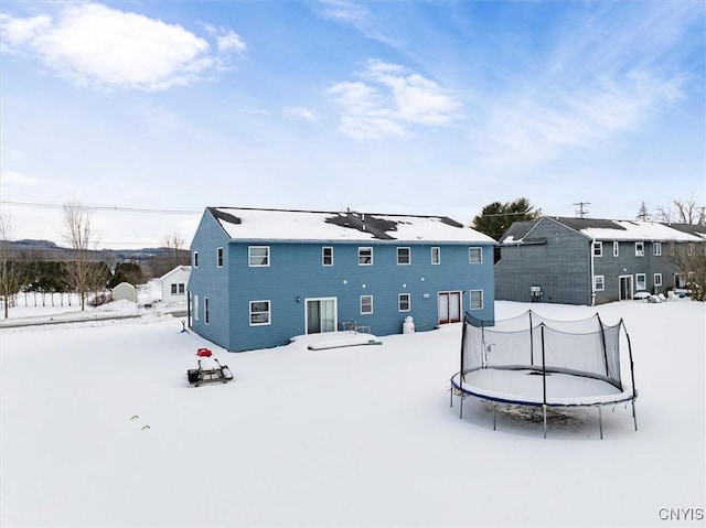 snow covered house with a trampoline