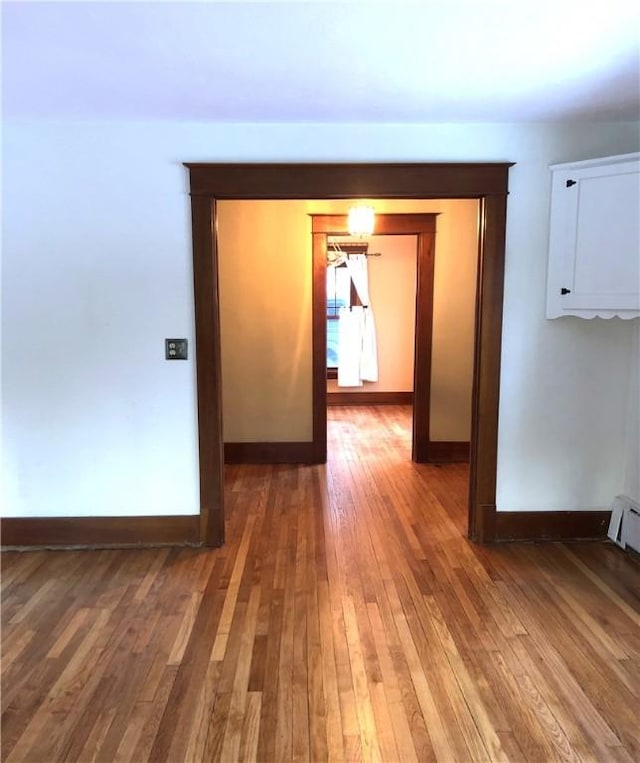 hallway with baseboards and hardwood / wood-style flooring