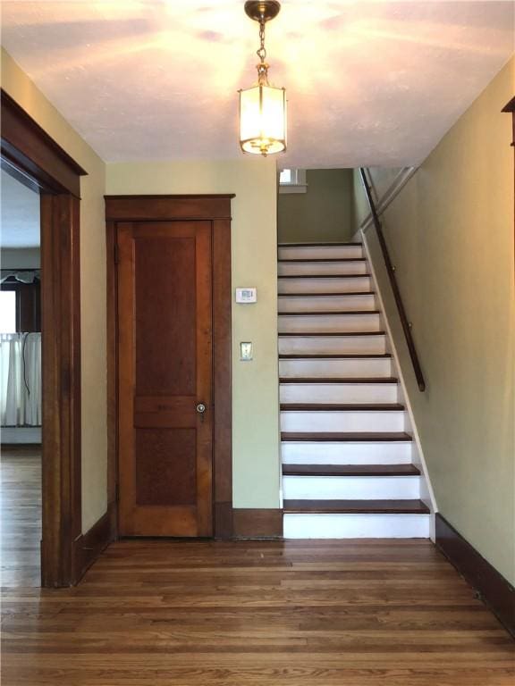 staircase with wood finished floors and baseboards