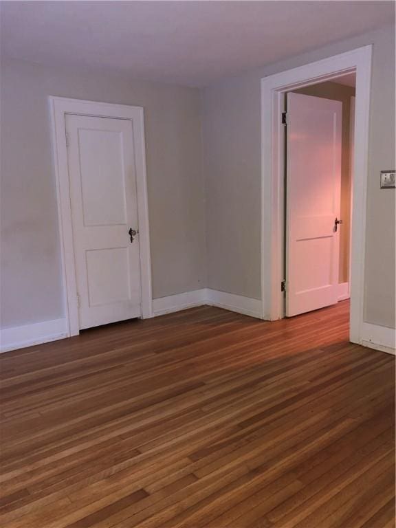 spare room with wood finished floors and baseboards