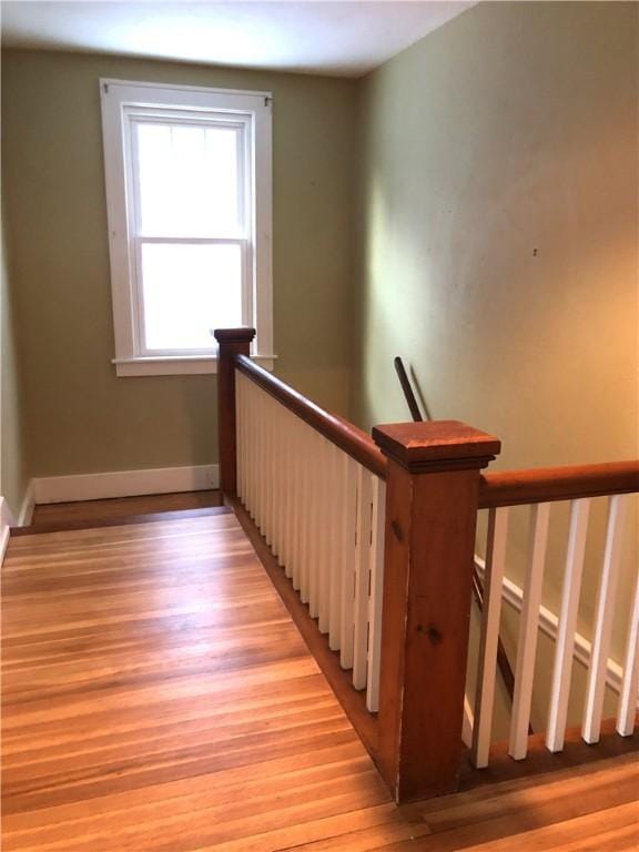 stairway with wood finished floors and baseboards