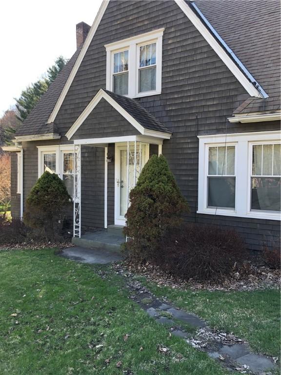view of front facade with a front lawn and a chimney