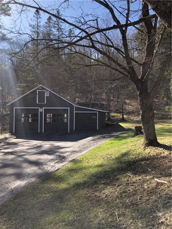 garage featuring driveway and a detached garage