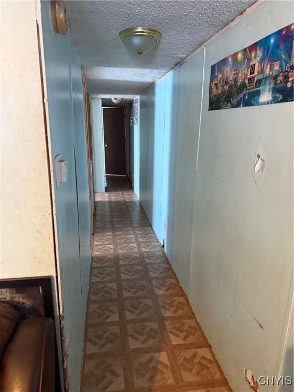 hallway with parquet floors and a textured ceiling