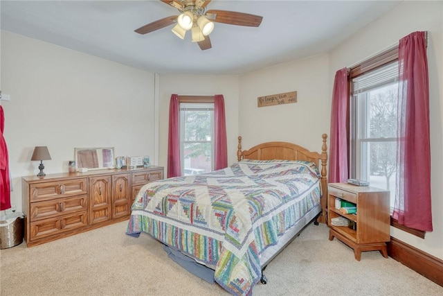 bedroom with ceiling fan and light carpet