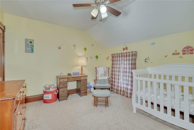 bedroom featuring ceiling fan, lofted ceiling, a nursery area, and carpet flooring