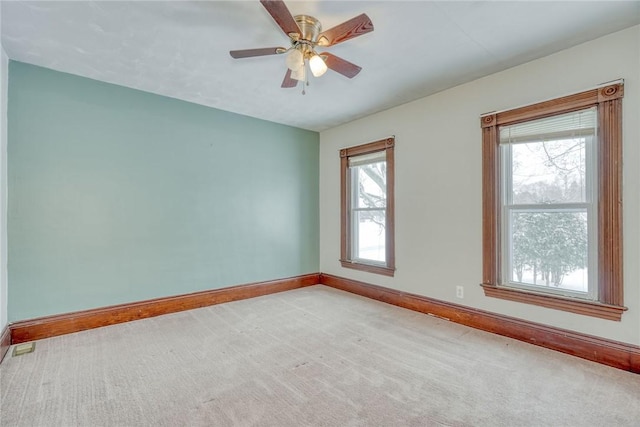 carpeted spare room featuring ceiling fan