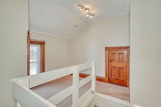 hall with vaulted ceiling and rail lighting