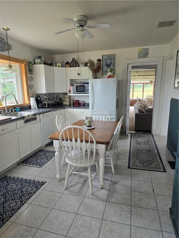 tiled dining space with ceiling fan and sink