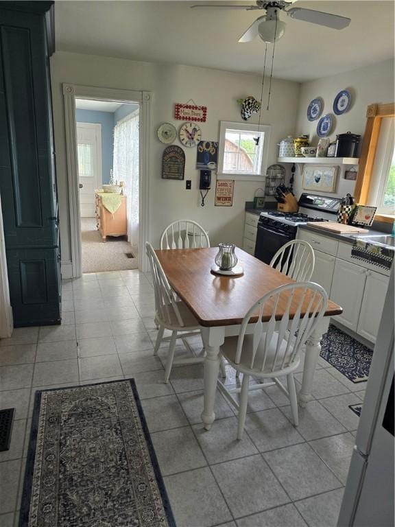 dining space featuring ceiling fan and light tile patterned floors