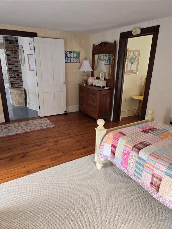 bedroom with dark hardwood / wood-style flooring