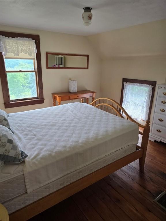 bedroom with dark hardwood / wood-style flooring