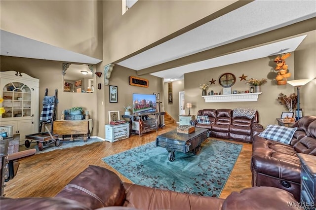 living room featuring a high ceiling and wood-type flooring