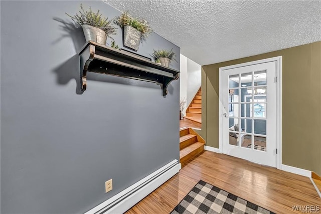 interior space with a baseboard radiator, a textured ceiling, and wood-type flooring