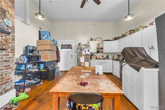 kitchen featuring decorative light fixtures, stainless steel refrigerator, white cabinets, and hardwood / wood-style floors