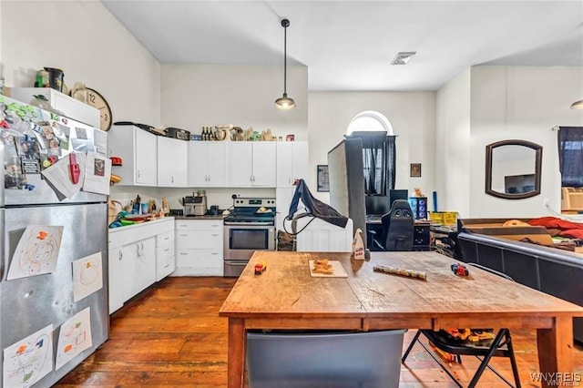 kitchen featuring white cabinets, stainless steel appliances, dark hardwood / wood-style flooring, and pendant lighting