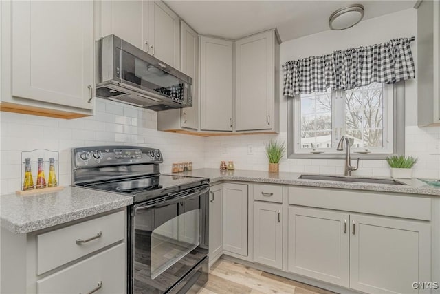 kitchen with sink, black range with electric stovetop, and light stone countertops