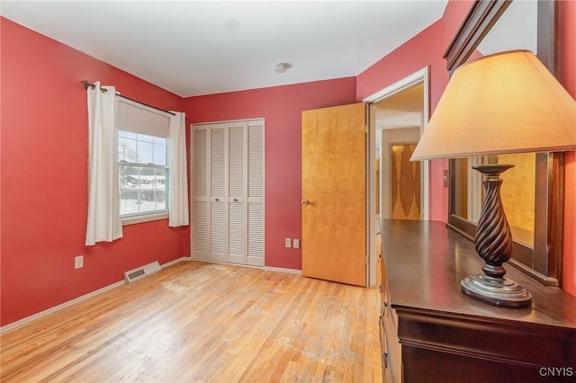 unfurnished bedroom with light wood-type flooring and a closet