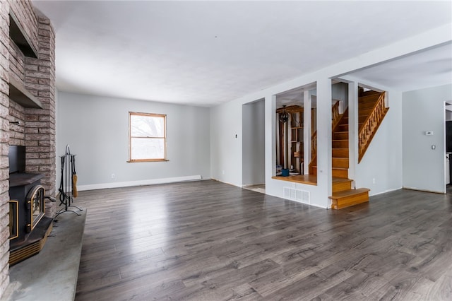 unfurnished living room featuring dark hardwood / wood-style floors and a wood stove