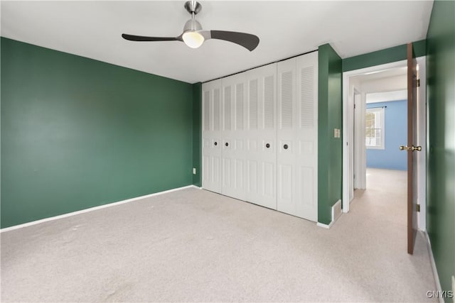 unfurnished bedroom featuring ceiling fan, light carpet, and a closet