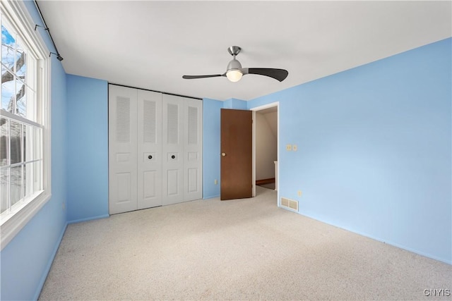 unfurnished bedroom featuring ceiling fan, carpet floors, and a closet