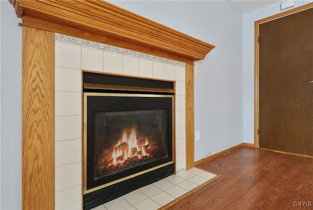 interior details featuring hardwood / wood-style flooring and a tiled fireplace