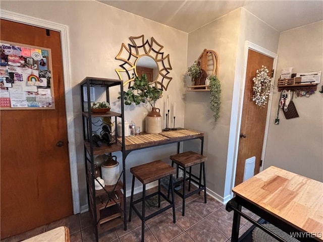 dining space featuring dark tile patterned flooring