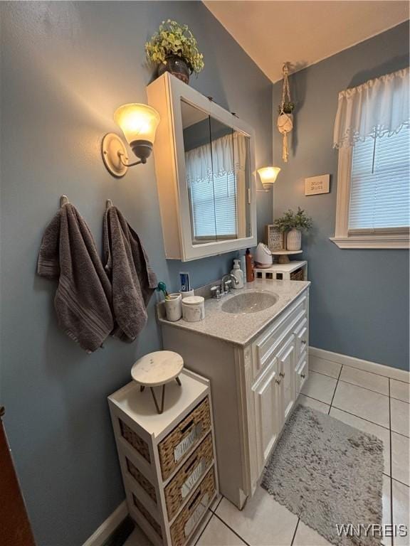 bathroom with tile patterned floors, vaulted ceiling, and vanity