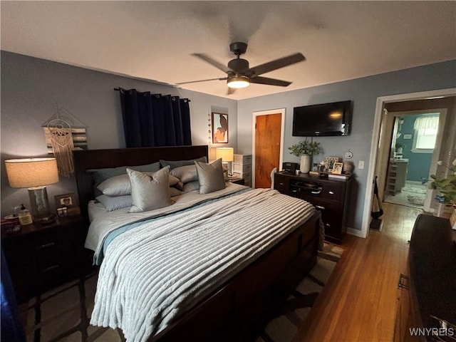 bedroom with connected bathroom, hardwood / wood-style flooring, and ceiling fan