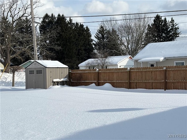 yard layered in snow featuring a shed