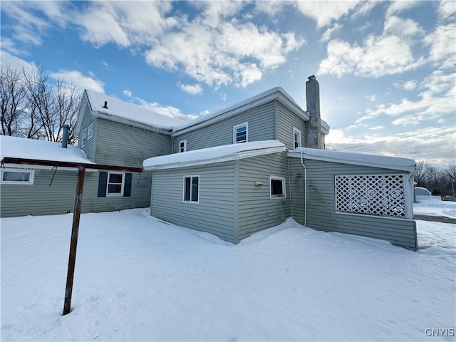 view of snow covered rear of property