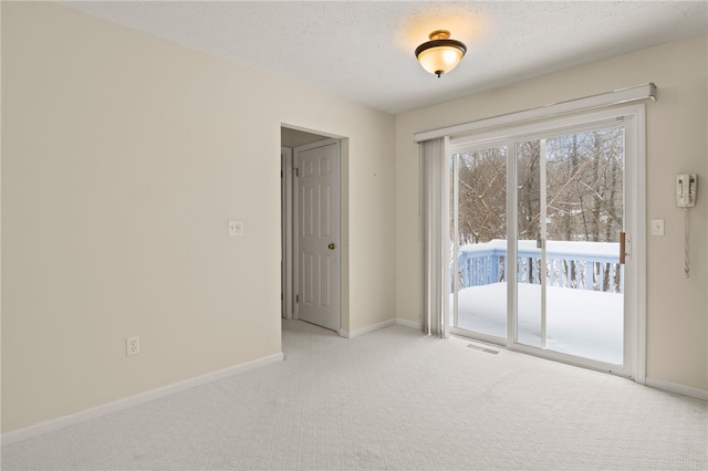 empty room featuring a textured ceiling and light carpet