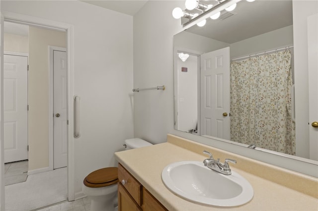 bathroom featuring toilet, vanity, and tile patterned flooring