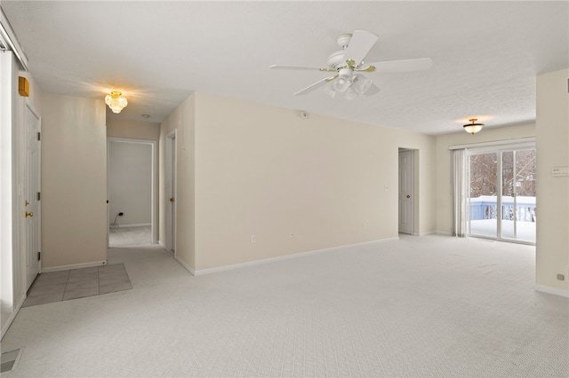 spare room with ceiling fan and light colored carpet