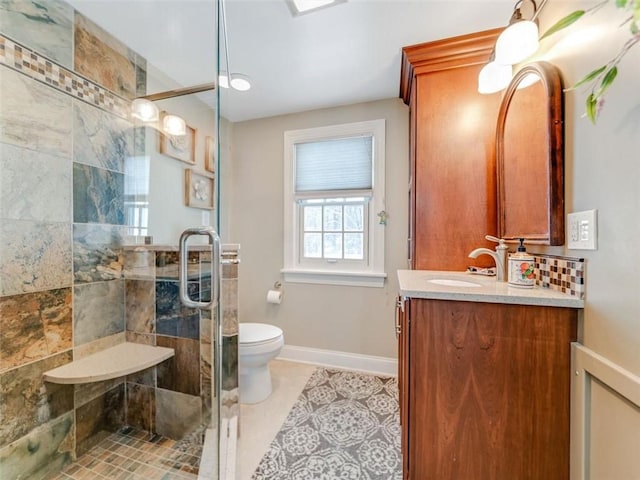 bathroom featuring tile patterned floors, vanity, toilet, and walk in shower