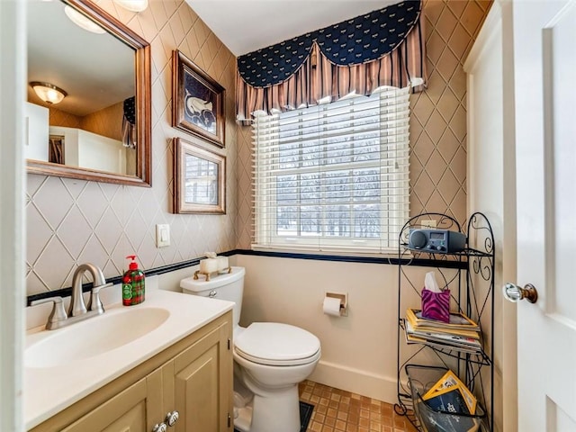 bathroom featuring vanity, toilet, and backsplash