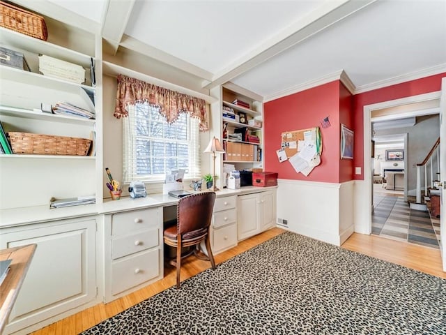 office space featuring light hardwood / wood-style flooring, built in desk, and ornamental molding