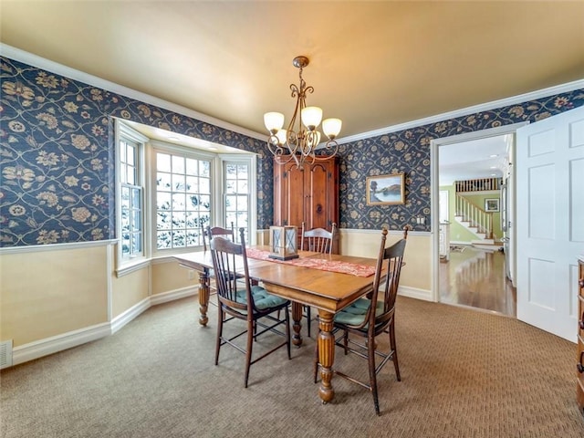 carpeted dining space featuring an inviting chandelier and crown molding