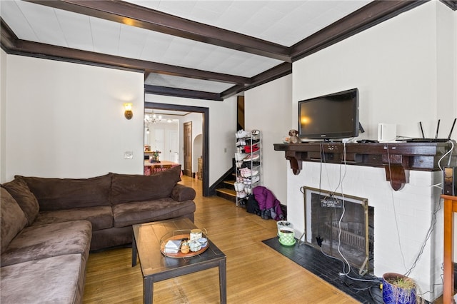 living room featuring a chandelier, hardwood / wood-style floors, and beamed ceiling