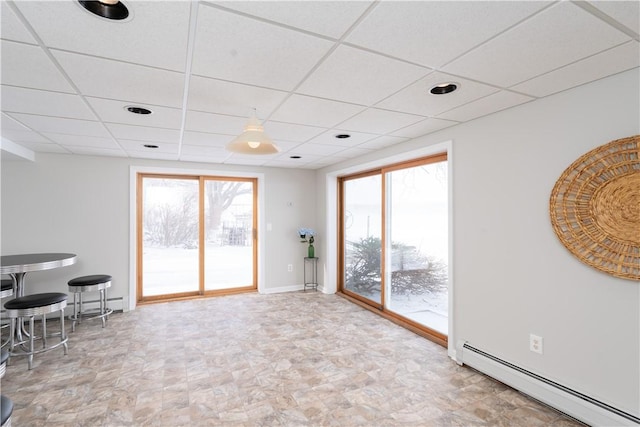 spare room featuring a drop ceiling and a baseboard radiator