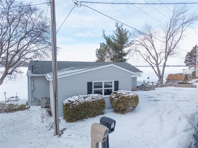 view of snow covered exterior featuring central AC unit