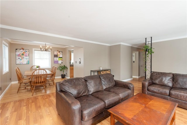 living room featuring an inviting chandelier, crown molding, and light hardwood / wood-style floors