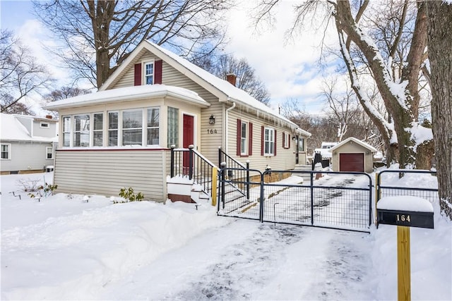 bungalow featuring a chimney, a gate, fence, and a garage