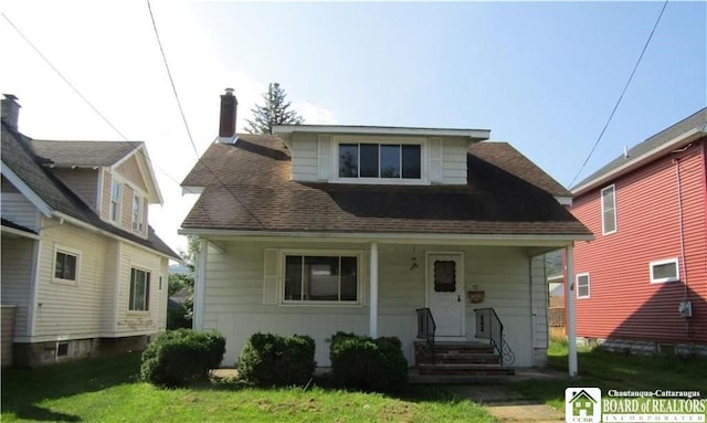 bungalow featuring a front yard and roof with shingles